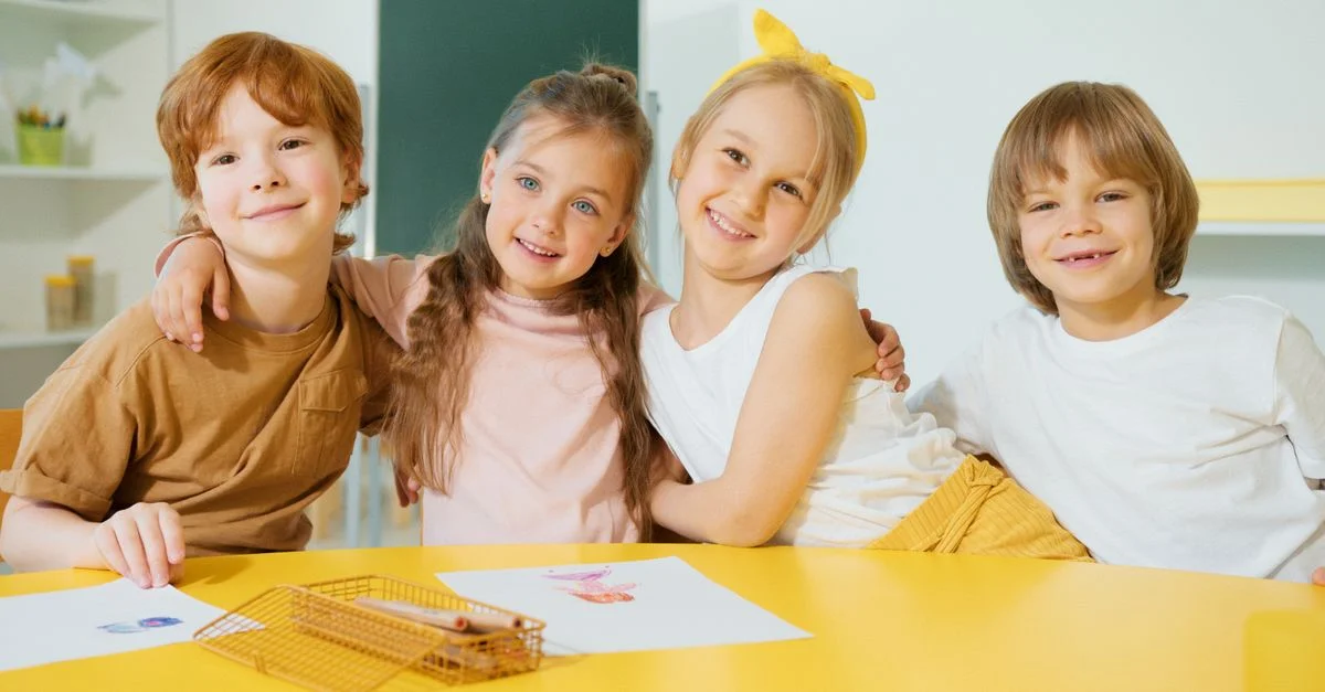 Grupo feliz de niños sonriendo y posando juntos en un aula luminosa.