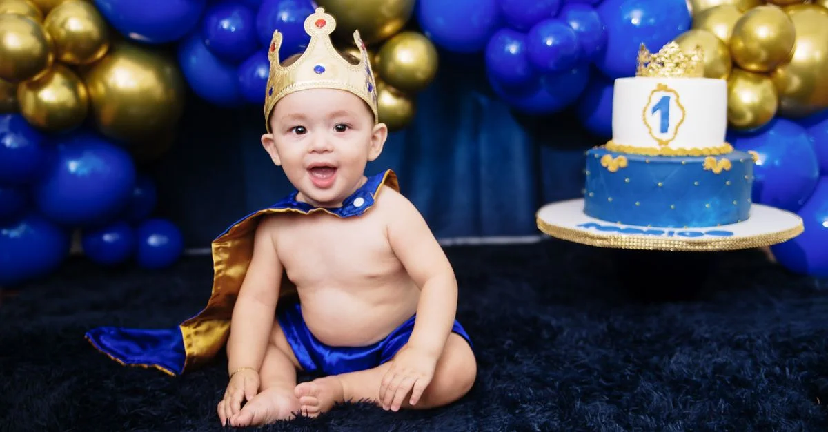 Lindo bebé niño vestido de príncipe celebrando su primer cumpleaños con un tema real.
