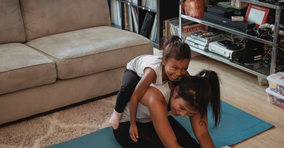 Una madre y su hija disfrutan de una sesión de yoga divertida en una acogedora sala de estar.