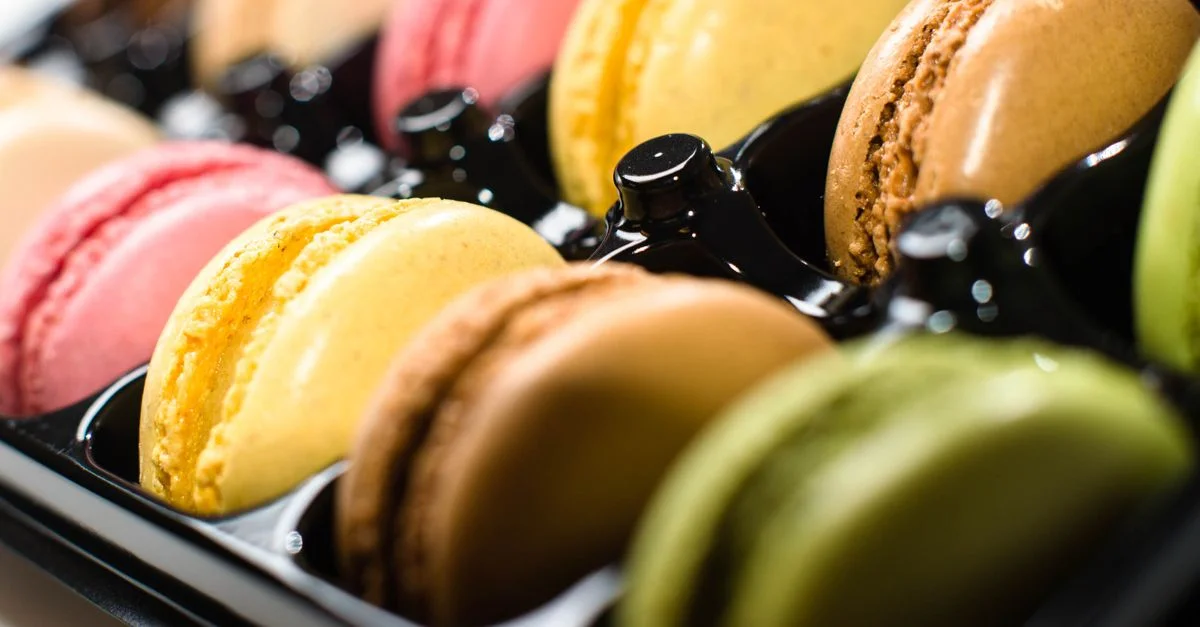 Vibrante surtido de macarons de diversos sabores en una bandeja negra.