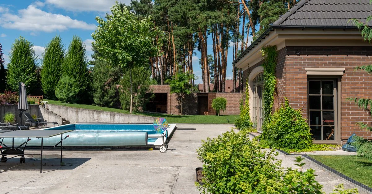 Hermosa casa suburbana con piscina privada y vegetación exuberante, perfecta para relajarse en verano.