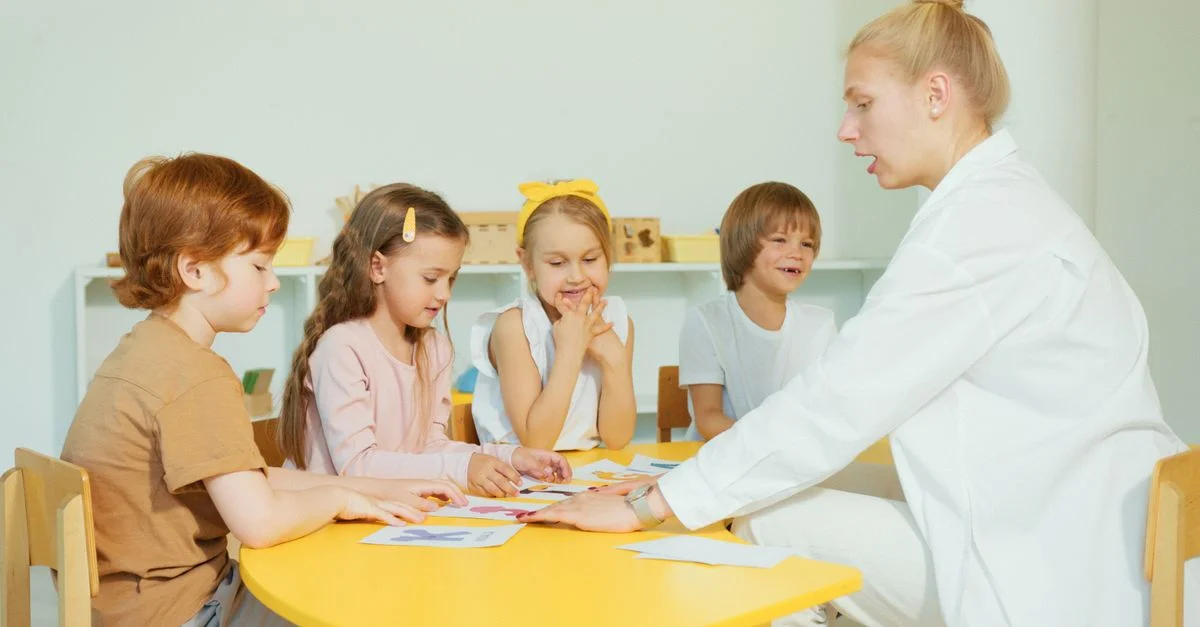 Niños en educación preescolar aprendiendo con una profesora durante una actividad divertida en el aula.