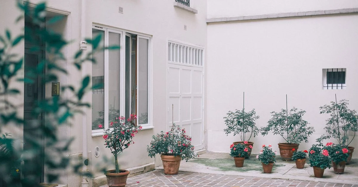 Encantador patio residencial con flores en macetas y arquitectura elegante, ideal para uso en fotos de stock.